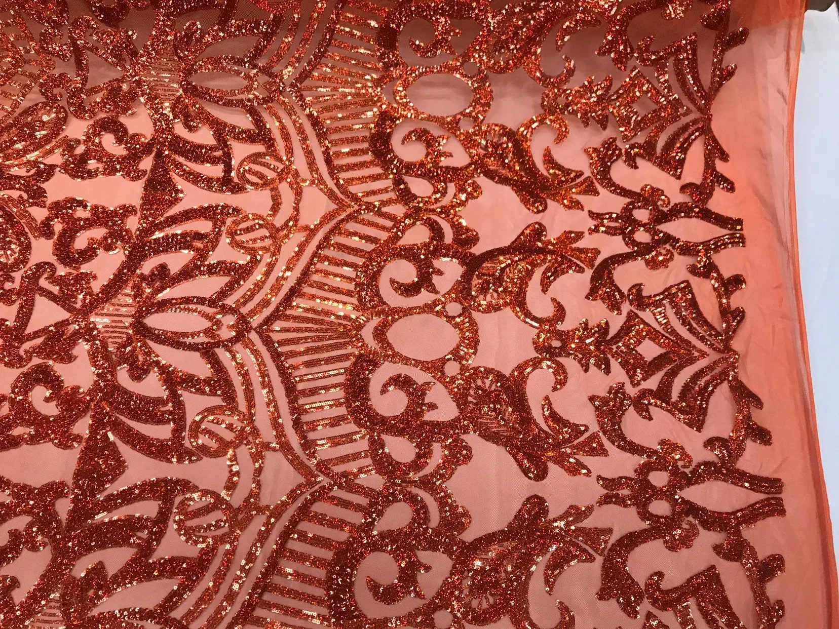 Burnt orange iridescent shiny sequin royalty design on a 4 way stretch mesh-sold by the yard.